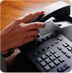 image of hand hanging up phone on desk