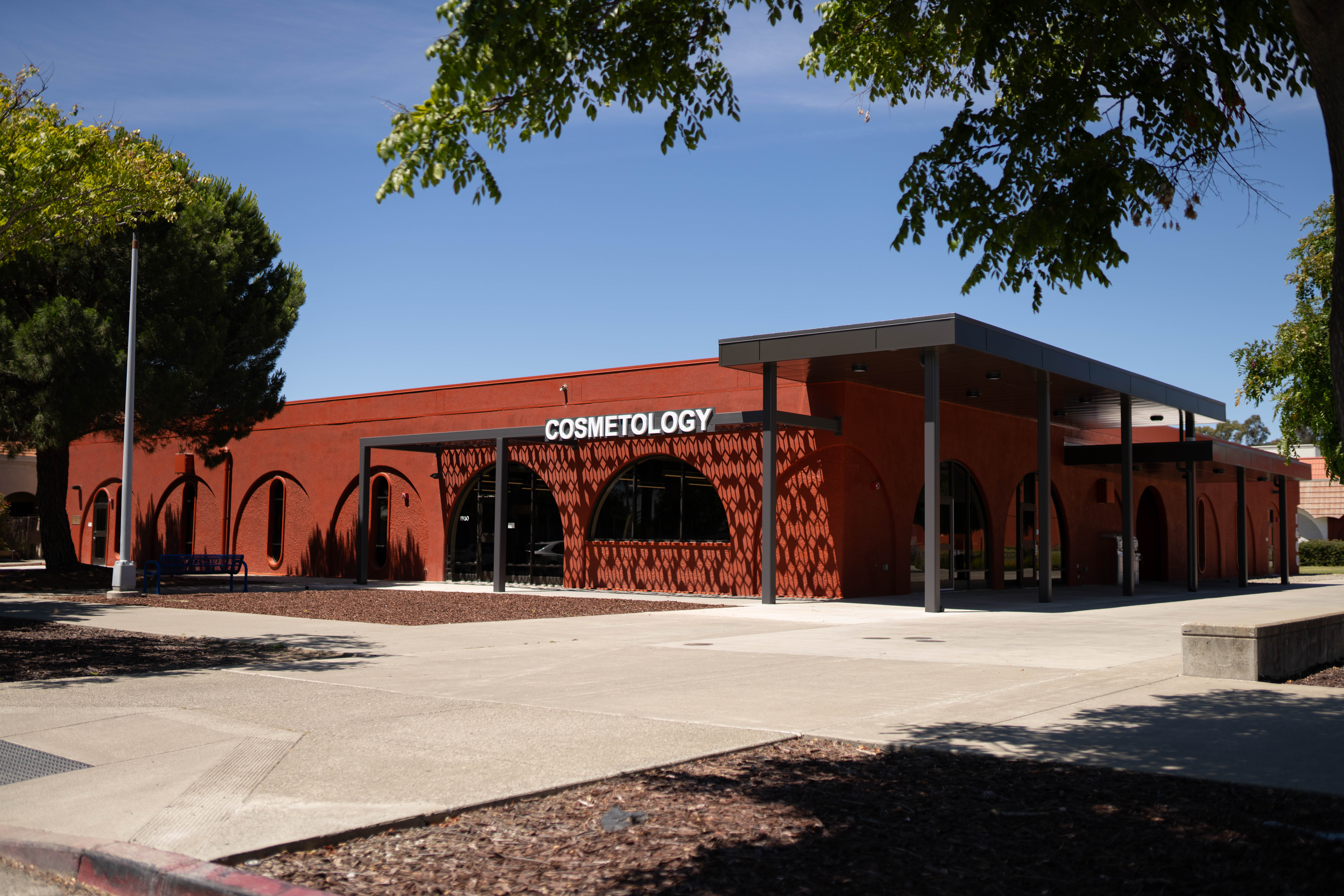 Exterior of red brick building, with Cosmetology text above window